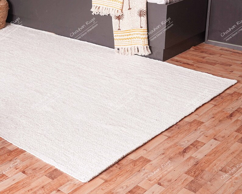 "Showcasing exceptional texture, this natural fiber rug is hand-woven using thick jute braids, resulting in a plush, tactile surface. The pale cream color reflects light beautifully, offering a bright, airy feel, making it an ideal choice for bedrooms or cozy reading nooks where comfort is key."