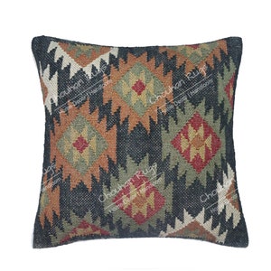May include: A square throw pillow cover featuring a dark charcoal background with a repeating geometric diamond pattern in shades of rust orange, olive green, and cream. The text "Chouhan Rugs Home Decor Handloom" is printed across the surface.