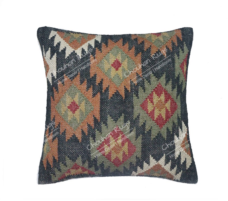 May include: A square throw pillow cover featuring a dark charcoal background with a repeating geometric diamond pattern in shades of rust orange, olive green, and cream. The text "Chouhan Rugs Home Decor Handloom" is printed across the surface.