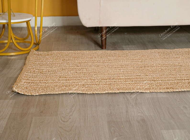 "An impressive example of sustainable home decor, this natural fiber runner offers a simple yet elegant solution for floor covering. The linear texture of the braids directs the eye and provides visual length, while the robust, thick construction guarantees long-lasting utility and rustic charm."
