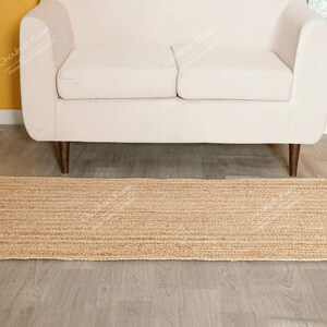 "This image features a high-quality, flatweave jute textile constructed through a meticulous hand-braiding process. The unadorned, warm color allows the rich, vertical texture to take center stage, making it an excellent, sustainable choice for adding quiet sophistication and warmth to any interior."