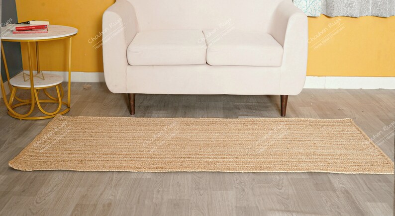 "This image features a high-quality, flatweave jute textile constructed through a meticulous hand-braiding process. The unadorned, warm color allows the rich, vertical texture to take center stage, making it an excellent, sustainable choice for adding quiet sophistication and warmth to any interior."