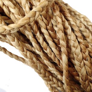 May include: Close-up of a thick, braided rope made from natural fibres. The rope is a light brown colour and has a rough texture.