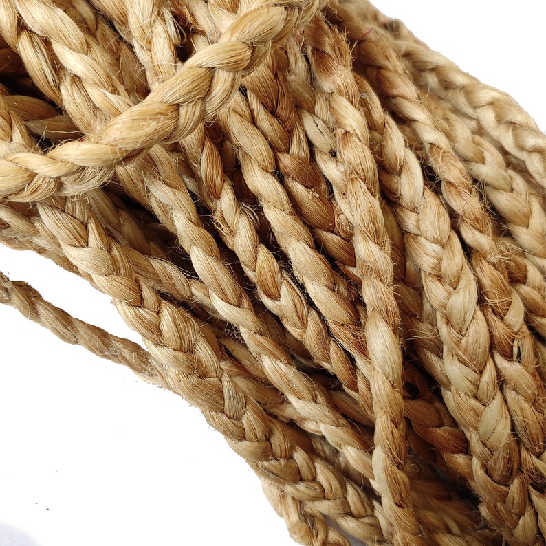May include: Close-up of a thick, braided rope made from natural fibres. The rope is a light brown colour and has a rough texture.