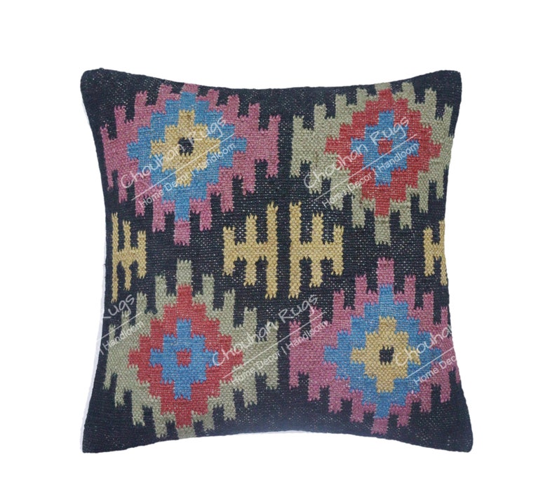 May include: A square throw pillow featuring a black background with a repeating geometric pattern in shades of blue, yellow, pink, red, and beige. The text "Chouhan Rugs Home Decor | Handloom" is overlaid multiple times across the surface of the pillow.