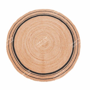 Puede incluir: Una alfombra redonda de fibra natural con un borde rayado en blanco y negro. La alfombra está hecha de un material tejido y tiene un color natural y terroso.