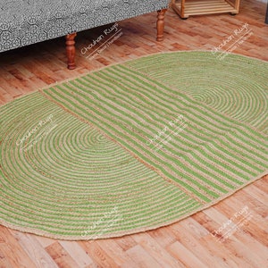 May include: An oval rug made from jute, featuring a striped pattern and a circular design. The rug is a natural colour and has a rustic look.