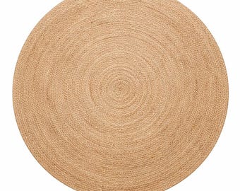 May include: A circular area rug crafted from natural tan fibers woven in a continuous spiral pattern. The rug features a consistent, tightly braided texture throughout its entire surface, creating a uniform and neutral appearance in a round shape.