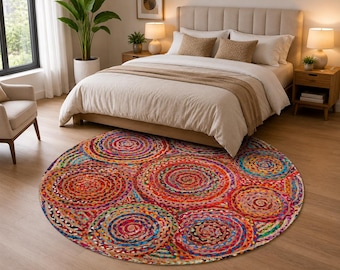 Op de afbeelding: Een rond, meerkleurig gevlochten vloerkleed met een levendig patroon van concentrische cirkels in tinten rood, oranje, geel, blauw en groen. Het kleed is gemaakt van geweven stoffen stroken, wat zorgt voor een getextureerd, rond ontwerp.