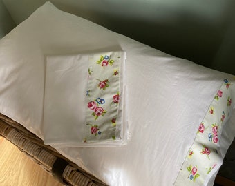 Vintage-style pair of white cotton pillowcases with patterned border