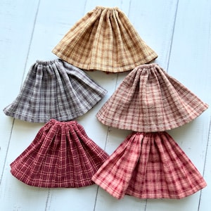 Pu&ograve; includere: Cinque gonne a quadri in diversi colori, tra cui marrone, grigio, rosso e rosa. Le gonne sono tutte realizzate in un tessuto morbido e tessuto e hanno una vita elastica.