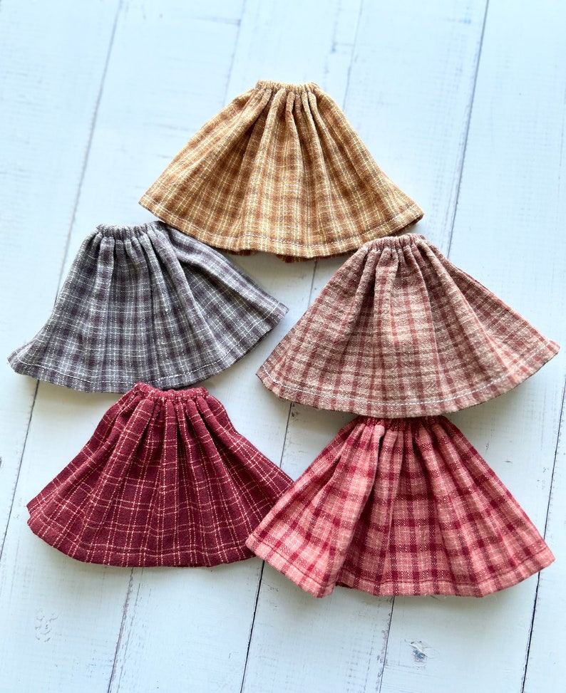 Pu&ograve; includere: Cinque gonne a quadri in diversi colori, tra cui marrone, grigio, rosso e rosa. Le gonne sono tutte realizzate in un tessuto morbido e tessuto e hanno una vita elastica.