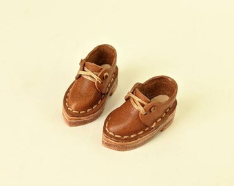 May include: A pair of brown leather shoes with laces. The shoes have a stitched design around the edges.