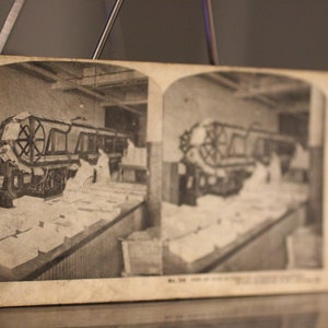 Antieke bekledingsmachine op drukpers - A Trip Through Sears, Roebuck & Co Stereoscope Viewer Card - Vintage Business Photography