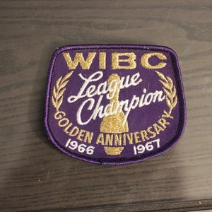 May include: Purple patch with gold embroidery. It reads "WIBC League Champion Golden Anniversary 1966 1967".