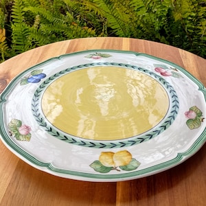 May include: Oval serving platter with a white base, a yellow center, and a green and white scalloped edge. The platter is decorated with fruit and floral motifs, including apples, cherries, and roses.