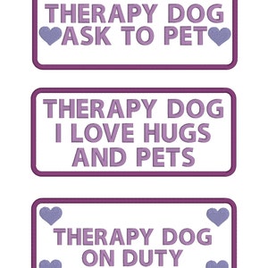 Pode incluir: Três patches retangulares roxos e brancos com o texto "Therapy Dog" e mensagens diferentes. O primeiro patch diz "Ask to Pet" com um coração de cada lado do texto. O segundo patch diz "I Love Hugs and Pets". O terceiro patch diz "On Duty" com um coração de cada lado do texto.