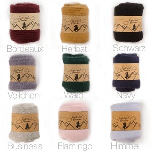 May include: Nine different colours of wool leg warmers with a brown label that says "Kuschel Merino". The colours are Bordeaux, Herbst, Schwarz, Veilchen, Wald, Navy, Business, Flamingo, and Himmel.
