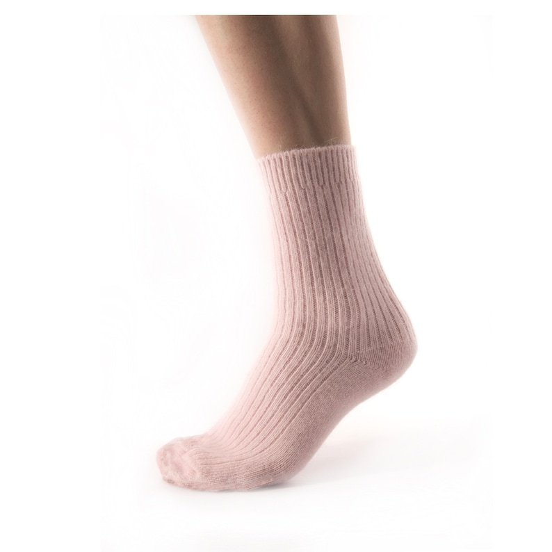 May include: A pair of pink ribbed socks made of soft, cosy material. The socks are ankle-length and have a comfortable fit.
