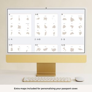 May include: A computer monitor displays a series of beige-colored map outlines, grouped in rectangular sections labeled with letters and numbers. A white keyboard and mouse sit below the monitor. The text at the bottom reads: Extra maps included for personalizing your passport cover.
