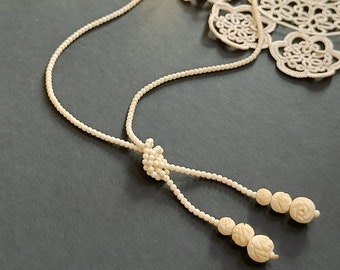 Collier vintage des années 1950 avec noeuds de perles gradués en celluloïd sculpté. Collier long à pampilles. collier vintage Lariat.