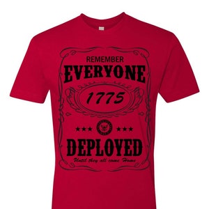 Könnte beinhalten: Ein rotes T-Shirt mit schwarzem Text. Der Text enthält "REMEMBER EVERYONE 1775 DEPLOYED" und "Until they all come Home". Das Shirt hat einen dekorativen Rahmen um den Text und ein militärisches Emblem.