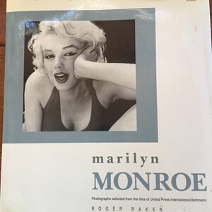 Op de afbeelding: Boekomslag met een zwart-witfoto van Marilyn Monroe, omlijst door een lichtblauwe rand. De titel "Marilyn Monroe" is in donkerblauwe letters onder de foto gedrukt. De naam van de auteur is ook zichtbaar.