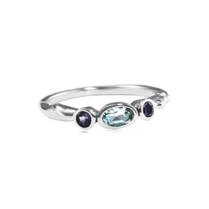 May include: A silver ring with three gemstones. The center stone is a light blue oval, and the two smaller stones are dark purple and round.