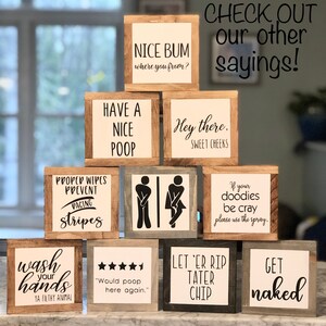 Peut inclure: Une collection de petits panneaux carr&eacute;s en bois avec des phrases humoristiques sur le th&egrave;me de la salle de bain, en lettres noires sur fond blanc. Les panneaux sont encadr&eacute;s en bois, avec des phrases comme "Nice Bum" et "Lavez-vous les mains."