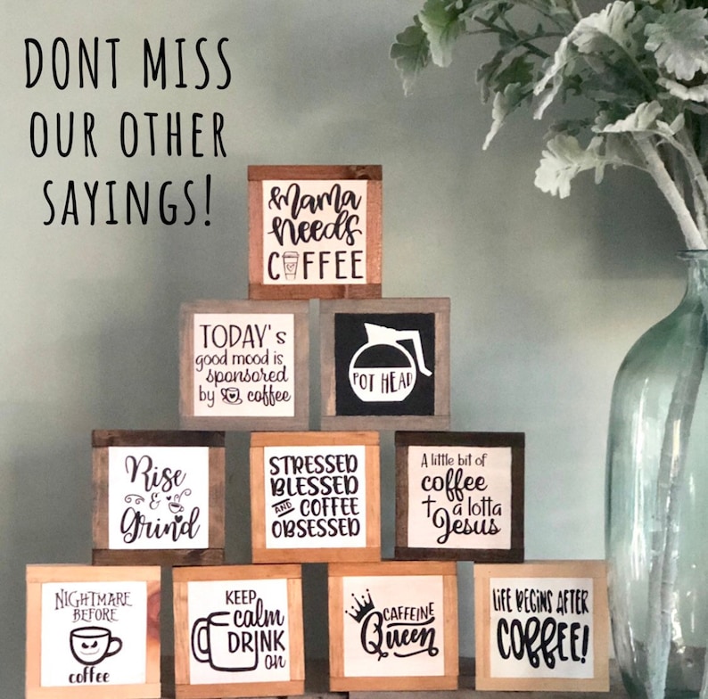 May include: A collection of 10 small wooden signs with various coffee-themed sayings. The signs are arranged in a pyramid shape on a shelf. The sayings include "Mama needs coffee", "Today's good mood is sponsored by coffee", "Pot Head", "Rise and Grind", "Stressed Blessed and Coffee Obsessed", "A little bit of coffee and a lotta Jesus", "Nightmare before coffee", "Keep calm drink on", "Caffeine Queen", and "Life begins after coffee!"