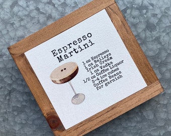 May include: A framed sign with the title "Espresso Martini" and a list of ingredients: 1 oz Espresso, 1 oz Baileys Irish Cream, 1 oz Vodka, 1/2 oz Coffee Liquor, 3-4 ice cubes, Coffee Beans for garnish. An illustration of an espresso martini in a martini glass is shown.
