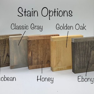 May include: Five wood samples stained in different colors: Classic Gray, Golden Oak, Jacobean, Honey, and Ebony. The samples are arranged in a row from left to right.