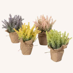 May include: Four artificial lavender plants in burlap pots. The plants are in different colors: purple, yellow, pink, and green.