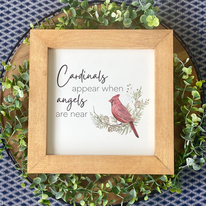 K&ouml;nnte beinhalten: Ein gerahmter Druck mit wei&szlig;em Hintergrund und einem roten Kardinal, der auf einem Ast sitzt. Der Druck lautet "Cardinals appear when angels are near".