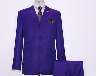 May include: A purple suit with a paisley patterned tie and a pocket square. The suit includes a jacket, trousers, and a pair of brown tassel loafers.