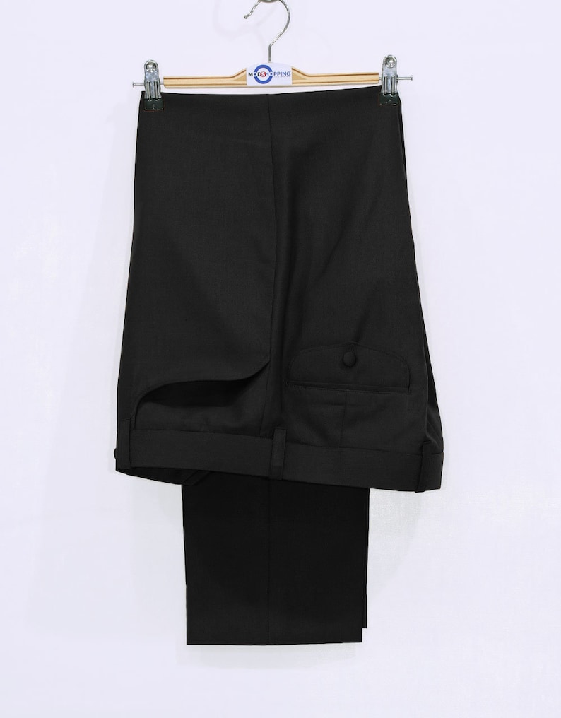 May include: Black dress pants hanging on a wooden hanger. The pants have a single button on the back pocket.