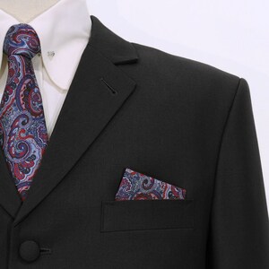 May include: A black suit jacket with a paisley patterned pocket square and tie. The jacket has a single button closure and a notch lapel.