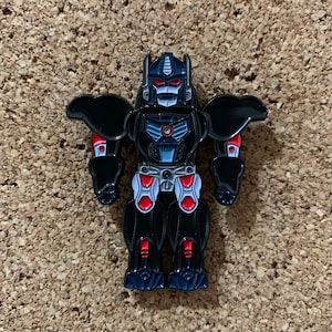 May include: Black and red robot pin with white accents. The robot has a large head with a red visor and a black body with red and white details.