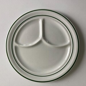 Puede incluir: Un plato dividido de cerámica blanca con un borde verde. El plato tiene tres secciones.