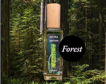 May include: A rectangular perfume bottle with a wooden cap, labeled "AKINA parfum" and "Forest." The bottle contains a green liquid and is set against a forest backdrop. The bottle is labeled "Forest" and contains 30ml.
