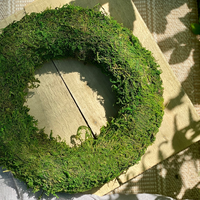 May include: A green moss wreath, perfect for adding a touch of nature to your home decor.