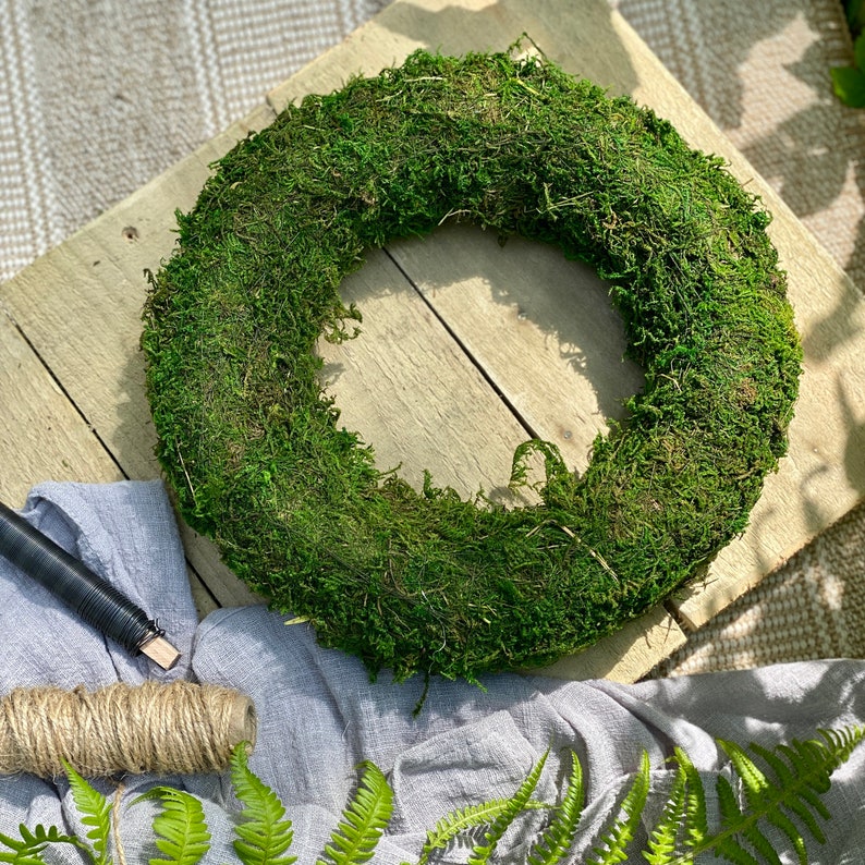 May include: A green moss wreath, perfect for adding a touch of nature to your home decor.