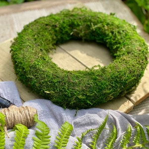 May include: A green moss wreath, perfect for a spring or summer door decoration. The wreath is made of natural moss and is approximately 12 inches in diameter.