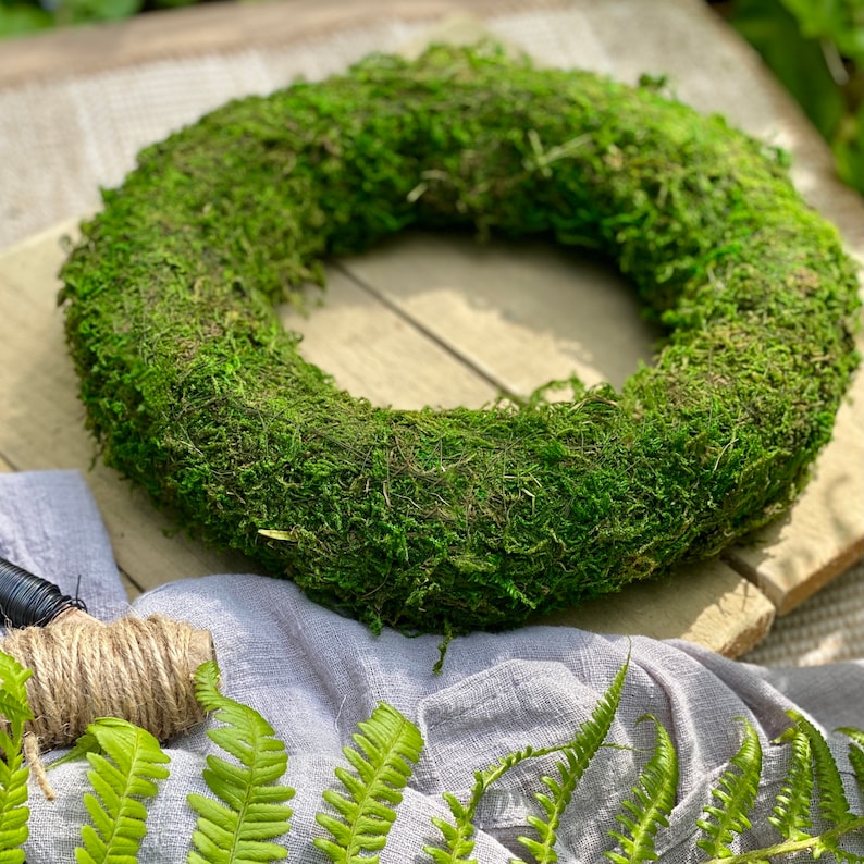 May include: A green moss wreath, perfect for a spring or summer door decoration. The wreath is made of natural moss and is approximately 12 inches in diameter.