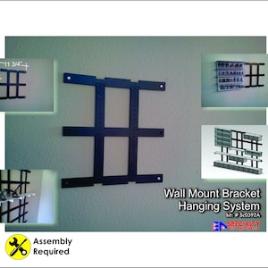 May include: Black metal wall mount bracket hanging system. The main bracket is 12 3/4 inches high and 11 3/4 inches wide. The image includes a diagram of the bracket and examples of how it can be used. The text reads "Wall Mount Bracket Hanging System" and "Assembly Required."
