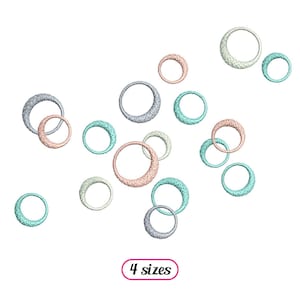 Puede incluir: Un diseño de bordado digital que presenta una colección de círculos superpuestos de varios tamaños y colores, incluyendo azul claro, rosa y gris. El diseño está etiquetado como "4 tamaños".