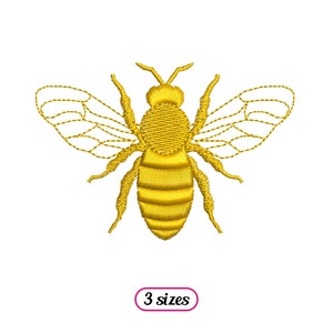 May include: An embroidered bee design in yellow, featuring wings and a segmented body. The bee is outlined in yellow thread.