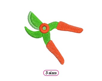 May include: An embroidered image of garden secateurs. The blades are green, the handles are orange, and the pivot point is red. The text "3 sizes" is in a pink oval.