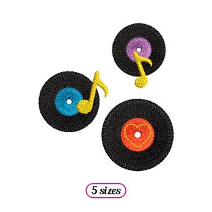 May include: Three black vinyl records with colorful designs. One record has a blue center with a yellow musical note, another has a purple center with a yellow musical note, and the third has a red heart in the center.