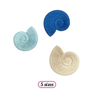 Op de afbeelding: Drie geborduurde schelpontwerpen in blauw, lichtblauw en beige. De schelpen zijn spiraalvormig. De tekst "5 maten" staat onder de schelpen.